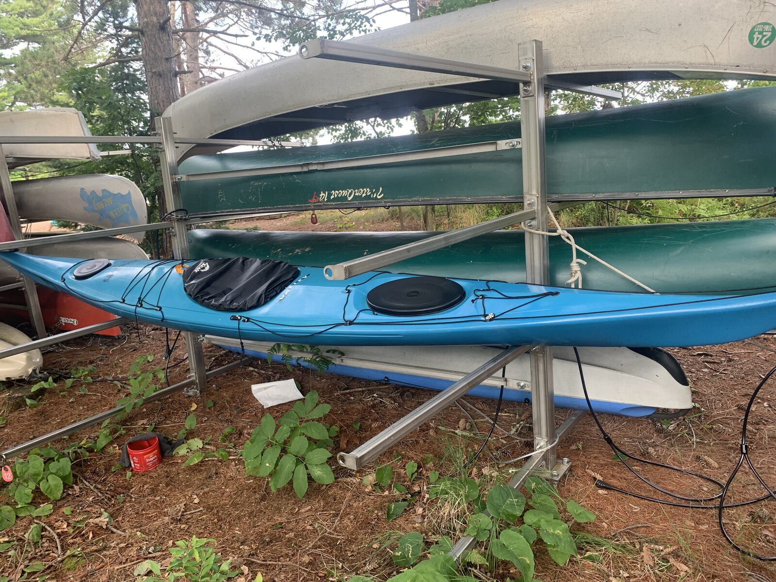 A blue Skerray kayak resting on its rack, cable-locked in place